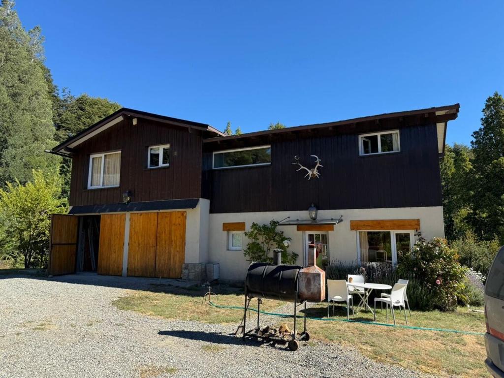 a large black and white house with a table at Casiopea bungalo in San Carlos de Bariloche