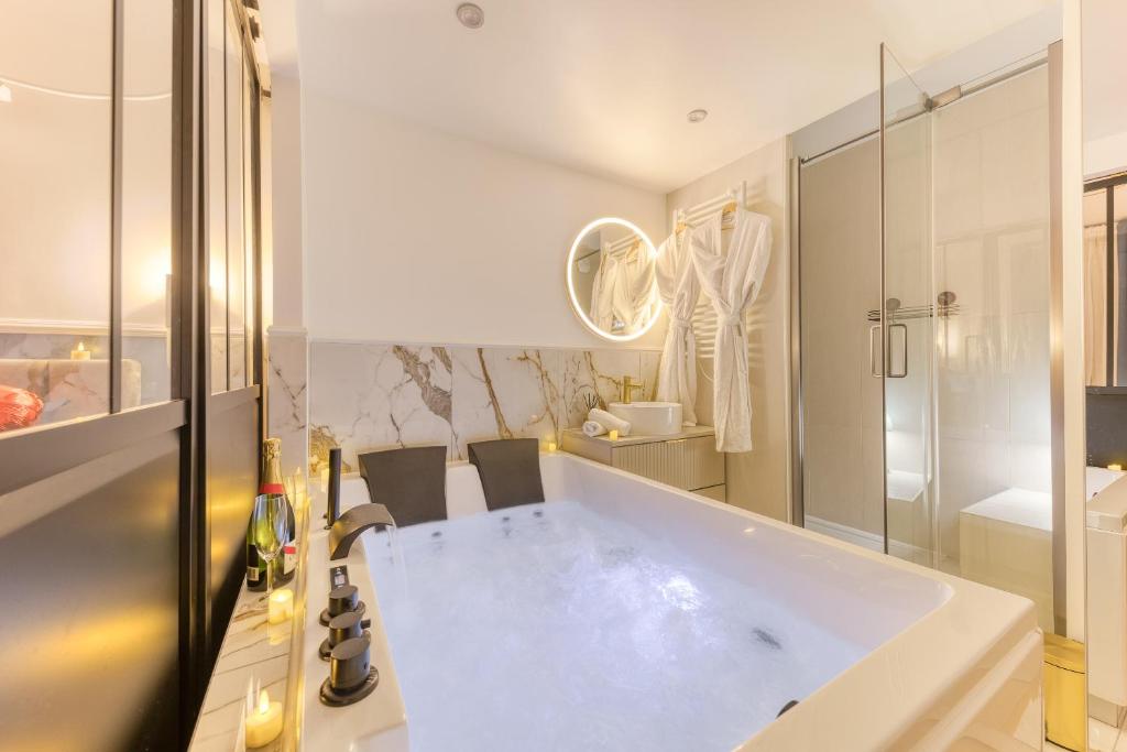 a bathroom with a large white tub in a room at Premium Spa Suite Jacuzzi Hot Tub Massage Chair near Paris Eiffel Tower-Stade de France-CDG Airport in Drancy
