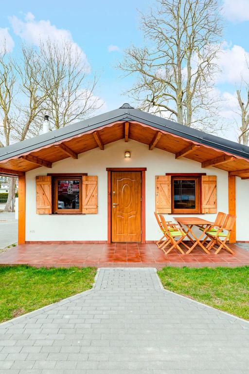 a small house with two chairs on a patio at Ferienhaus Ustronie I Nr 1 in Ustronie Morskie