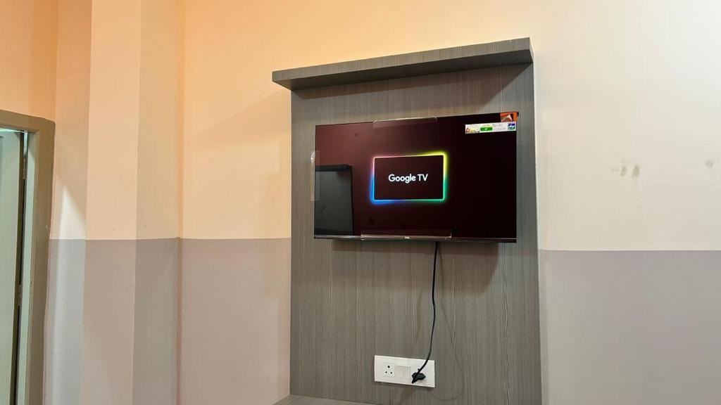 a small tv on a wall in a room at Hotel Monsoon in Warangal