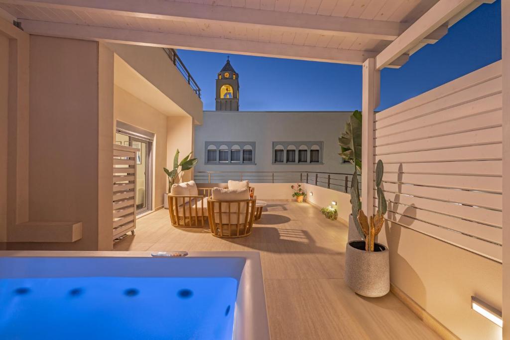 a balcony with a hot tub and a clock tower in the background at Rhodes center Santa Marina in Rhodes Town