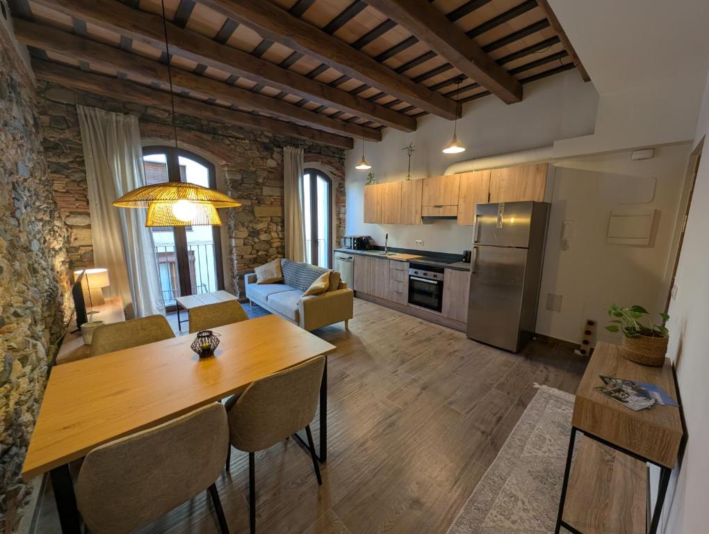 a kitchen and living room with a wooden table at Ca la Ministra in Amer