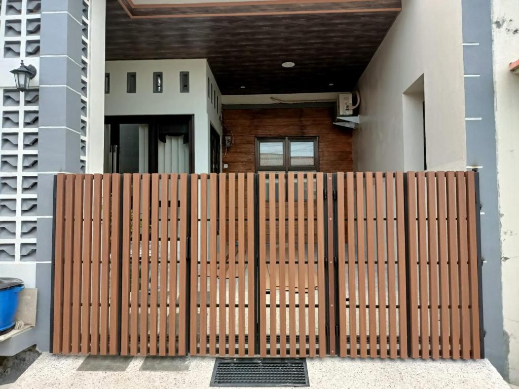 a wooden gate in front of a house at Homestay Berlian T in Alastuwo