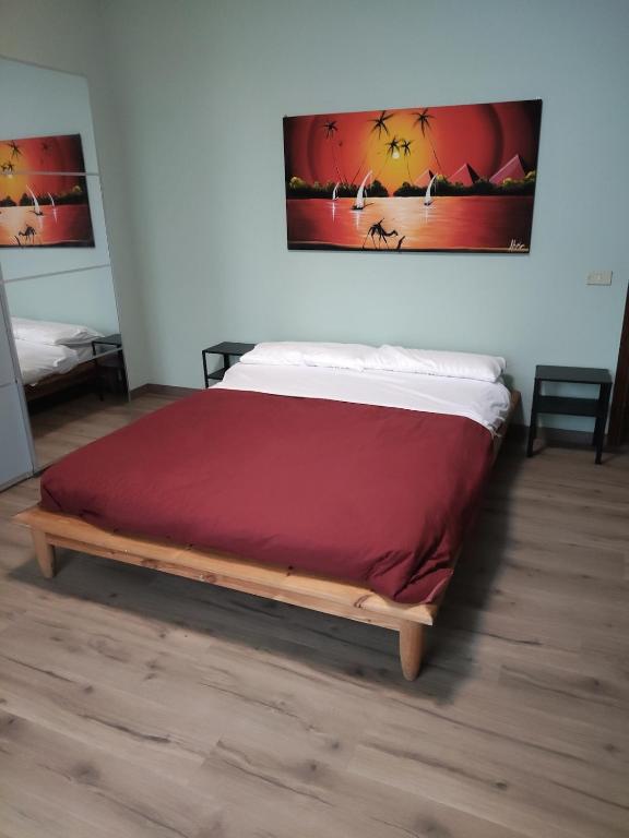 a bed in a room with a red blanket on it at Malpensa - Bilocale indipendente in Samarate