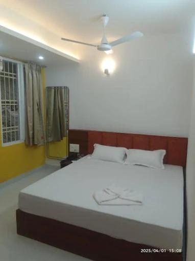 a bedroom with a large bed with a ceiling fan at kanta heritage hotel in Koch Bihār