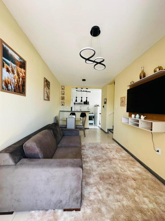 a living room with a couch and a flat screen tv at Condomínio Orla de Atalaia in Aracaju
