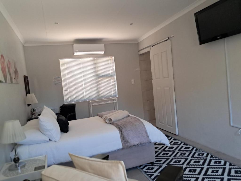 a bedroom with two beds and a television in it at Silwerrand in Beaufort West