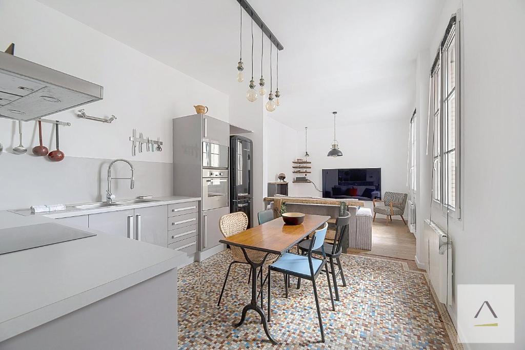 une cuisine avec une table et des chaises dans une pièce dans l'établissement L'Odorico, à Rennes
