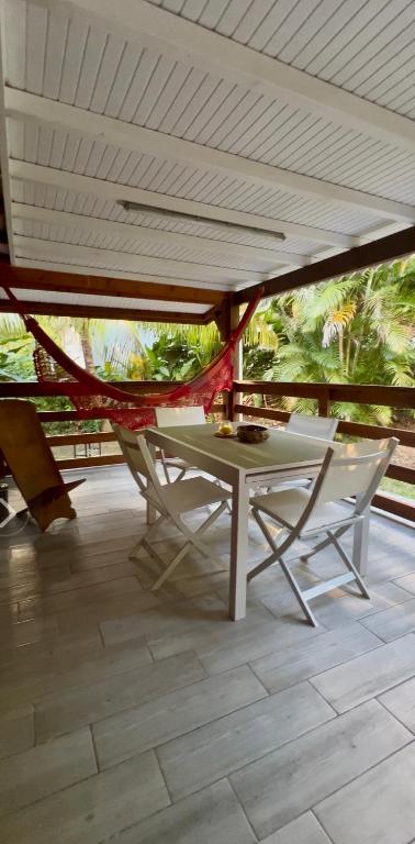 a table and chairs on a patio with a roof at La Maison du Bonheur in Pointe-Noire