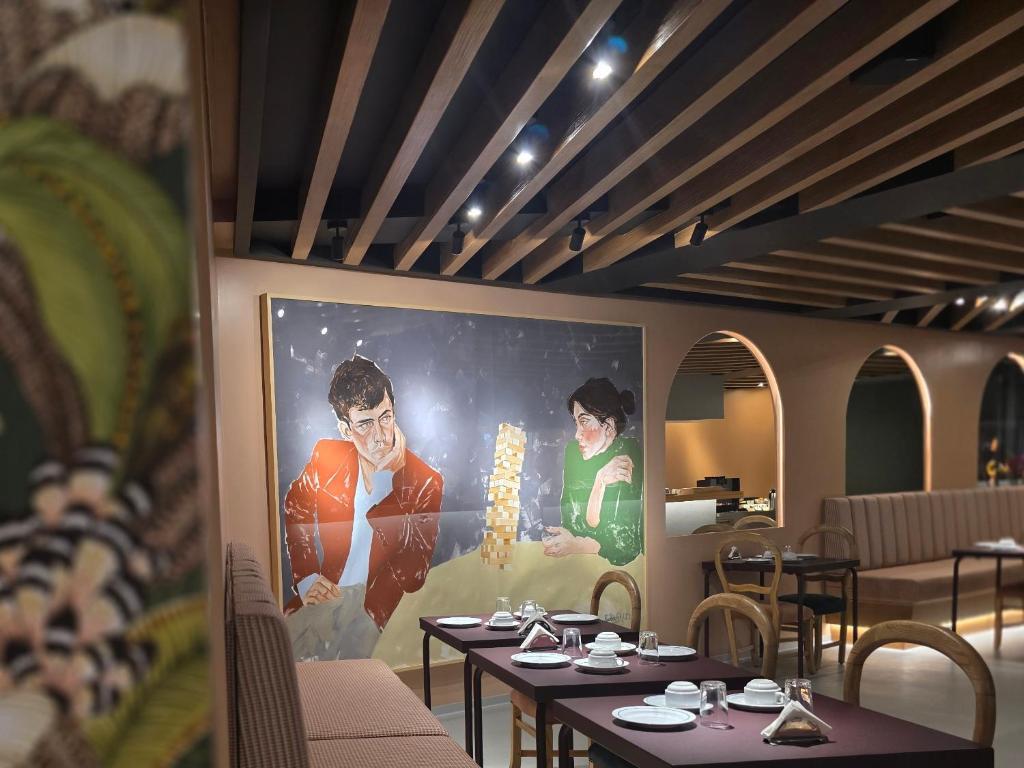 a restaurant with tables and a large painting on the wall at ASPA Studios - Urban Conscious Living in Funchal