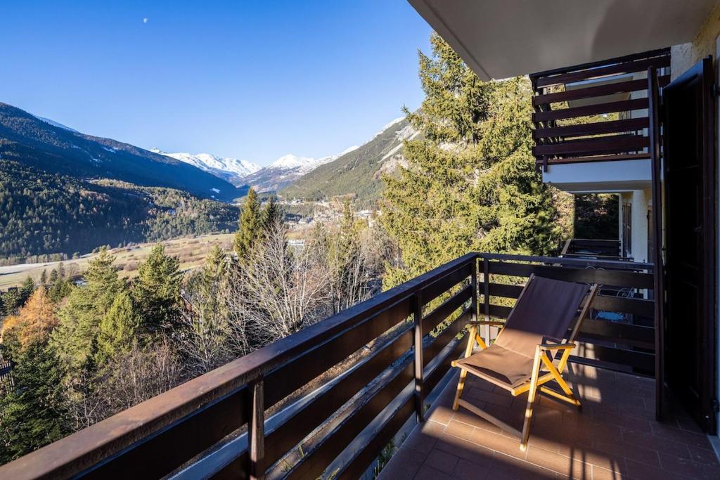 a chair on a balcony with a view of mountains at Bormio's Balcony - At the Spa in Premadio