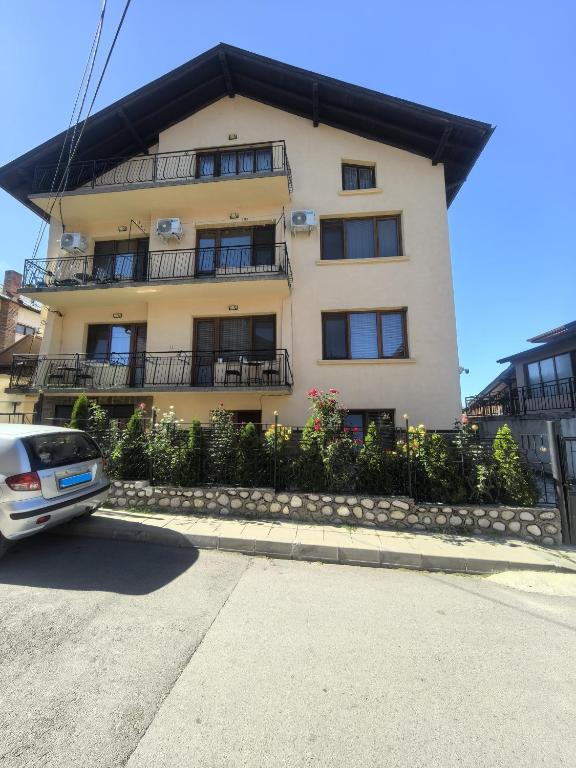 a building with a car parked in front of it at Tsvetkovi Guest House in Dobrinishte