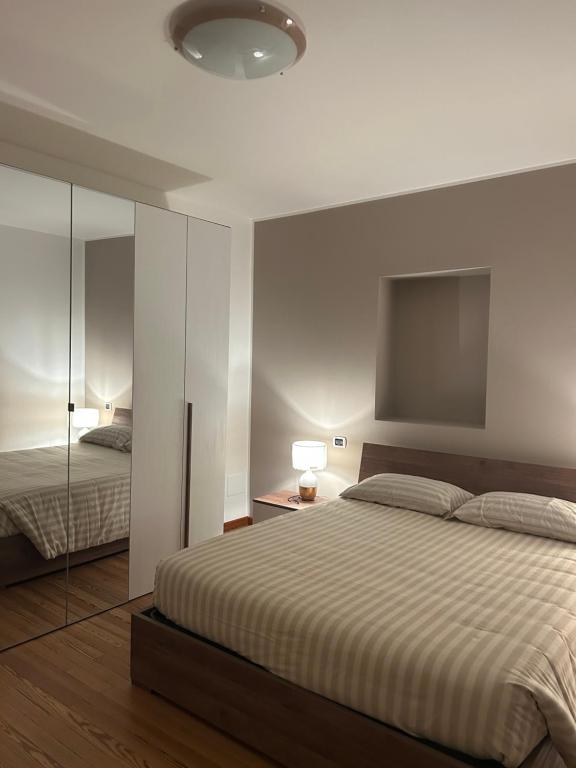 a bedroom with a large bed and a mirror at In Centro in Domodossola