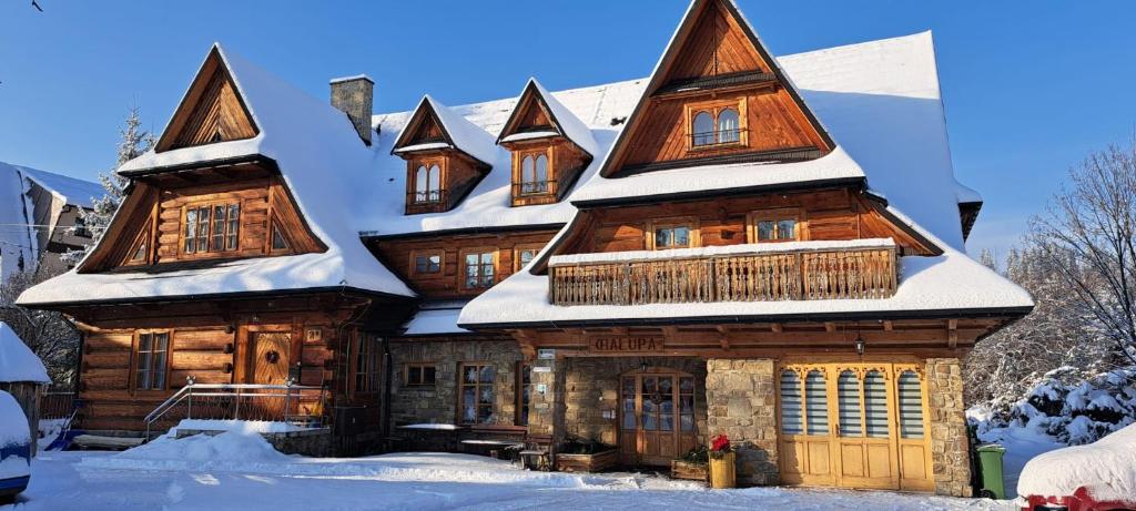 a log cabin with snow on its roof at CHAŁUPA Pokoje Gościnne in Poronin
