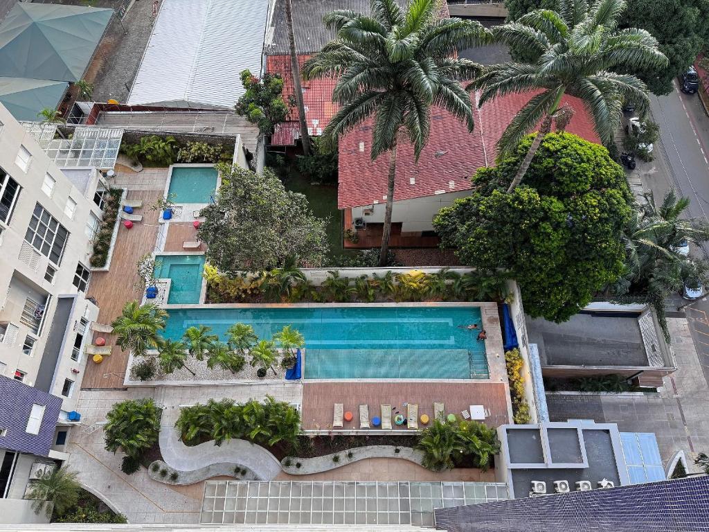 an overhead view of a swimming pool with palm trees at Luxurious 2-Bedroom Duplex with Gourmet Balcony in Goiânia