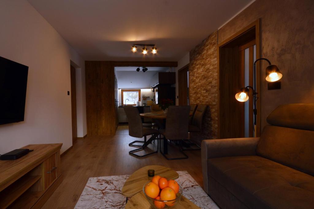 a living room with a couch and a table at Apartament Pod Jasieniem Jurgów in Jurgów