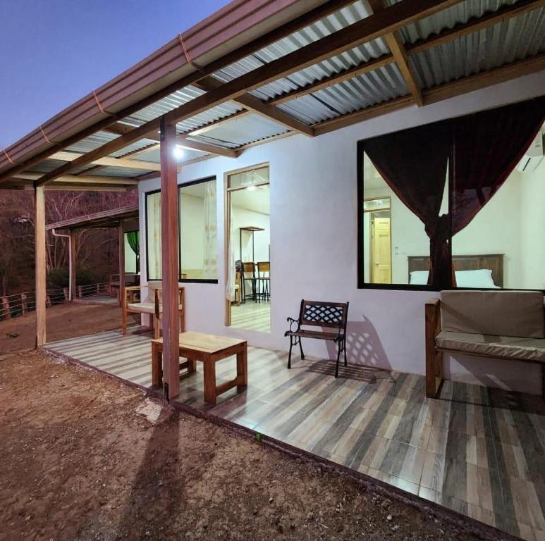 a covered patio with a couch and a table at Papaturro House in La Cruz