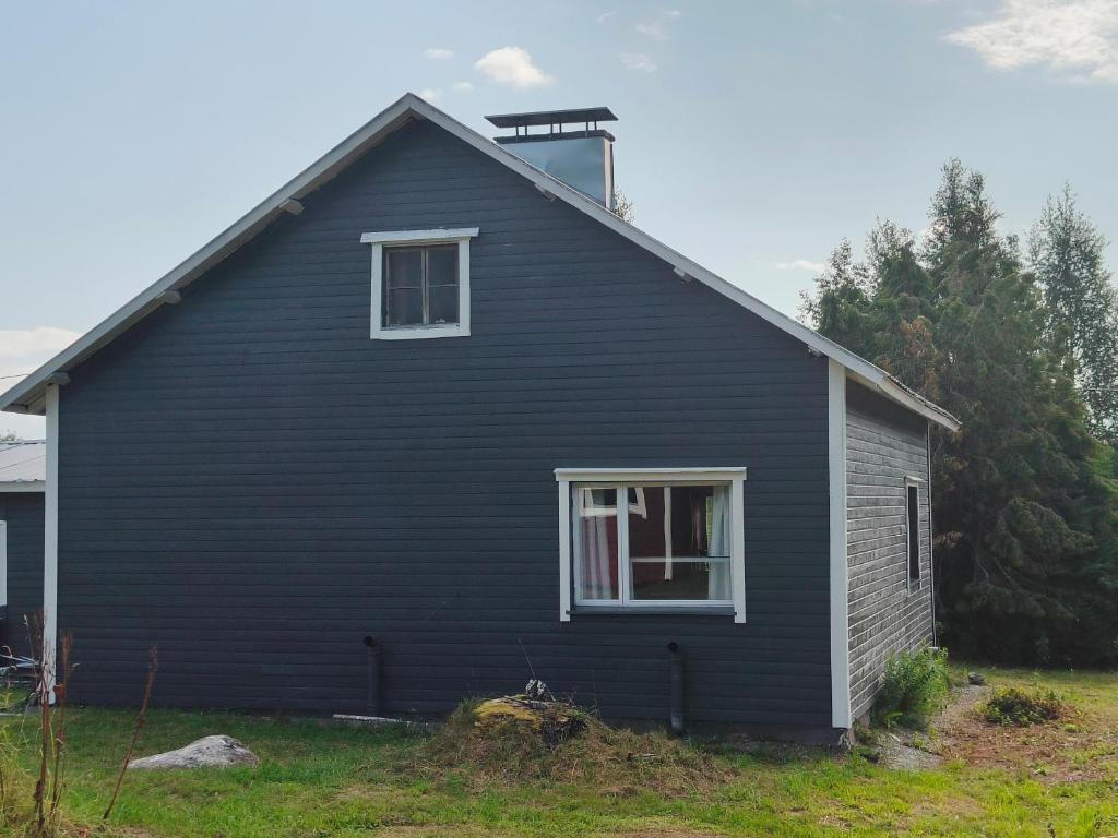 a black house with a window on the side of it at Northern Cabin in Havukkavaara