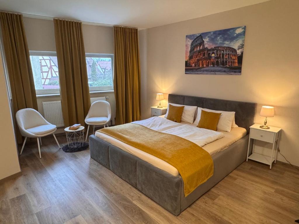a bedroom with a bed with two chairs and two windows at Schloss Casa Lauf an der Pegnitz Zimmer Rom in Lauf an der Pegnitz