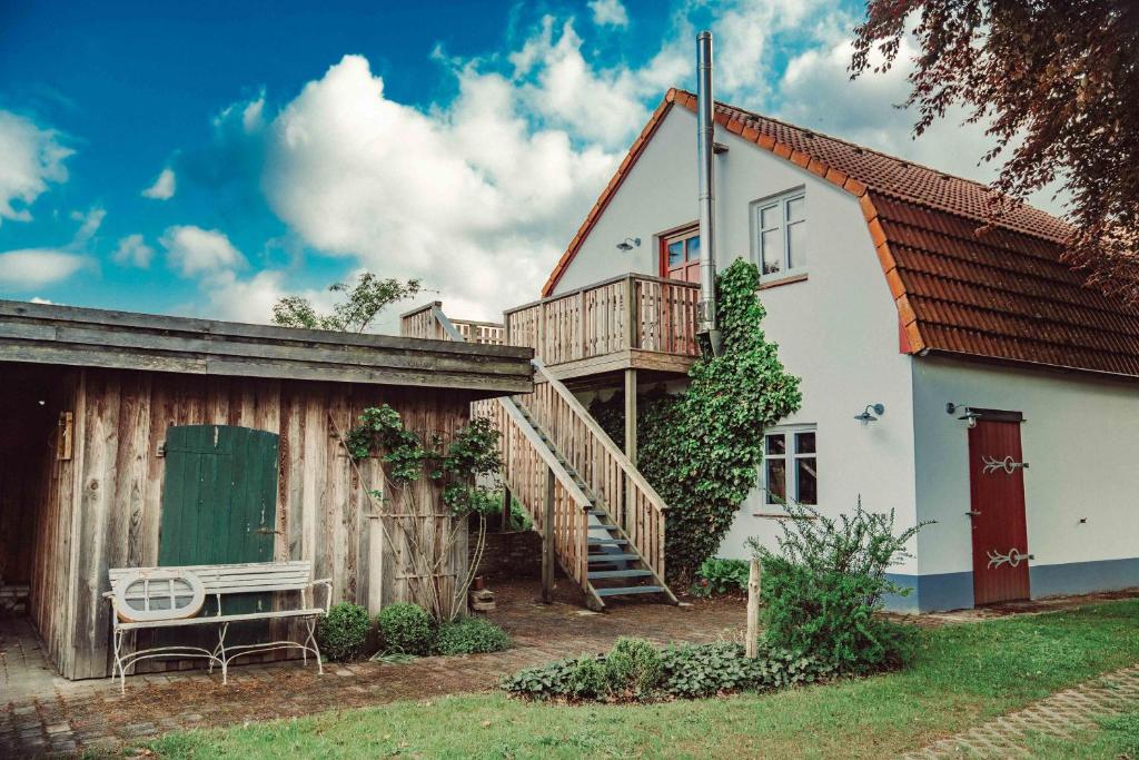 a white house with a deck and a staircase at Ferienwohnung Ausblick in Süderbrarup