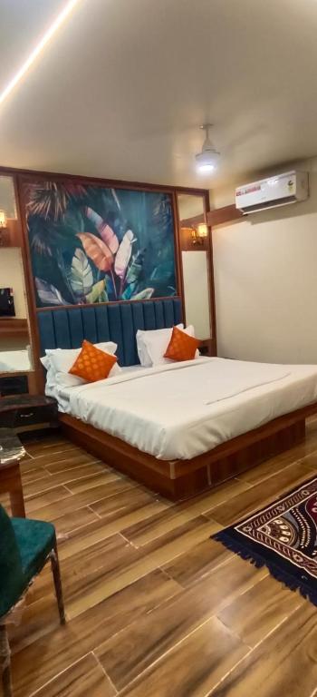a bedroom with a bed with a painting on the wall at Hotel Gandharva Executive in Pune