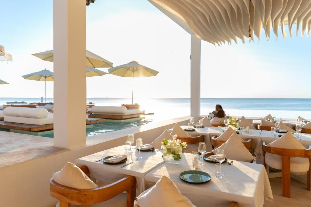 a restaurant on the beach with tables and chairs at Le Saint Tropez in Kidoti