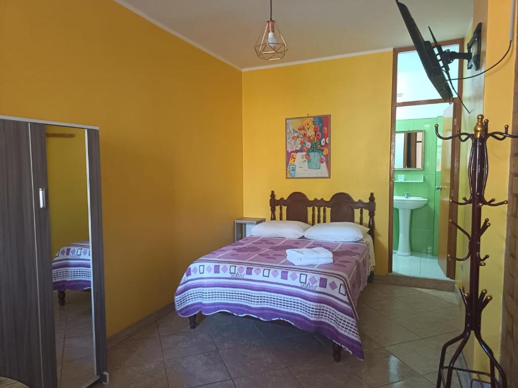 a bedroom with a bed with yellow walls at Nasca Trails B&B in Nazca