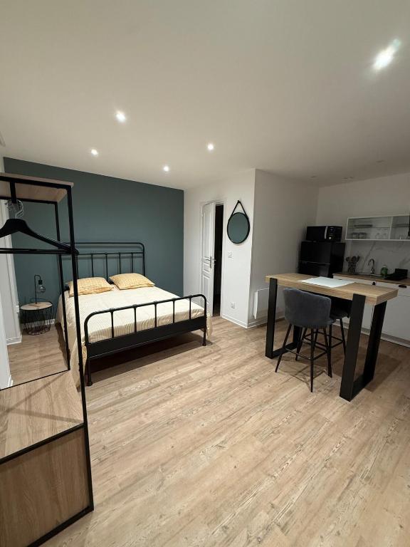 a bedroom with a bed and a desk and a table at Studio moderne tout confort in Vierzon