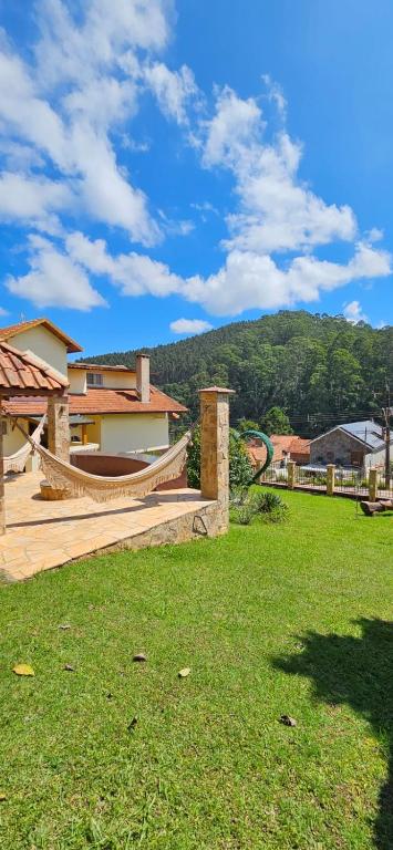 a yard with a hammock and a house at Pousada Winterhaus in Monte Verde
