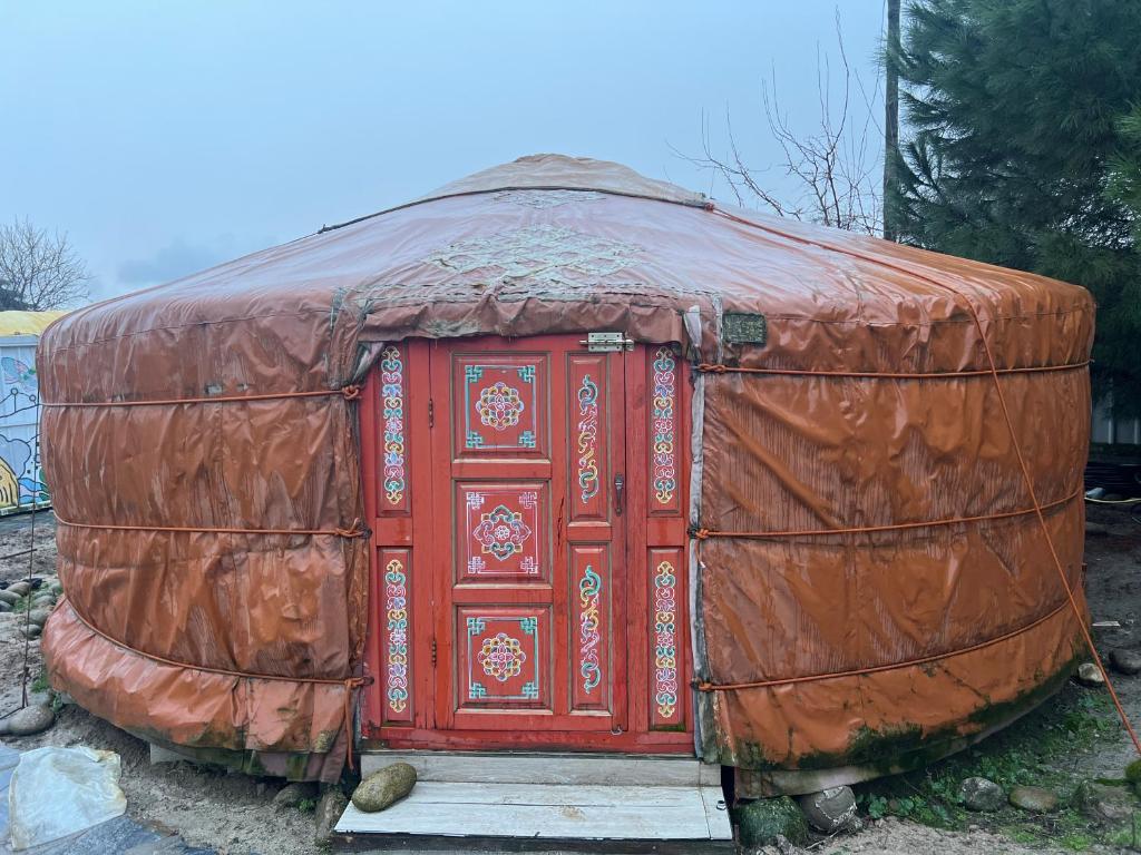 a large red object is sitting on the ground at Yurta cerca de Madrid in Madrid