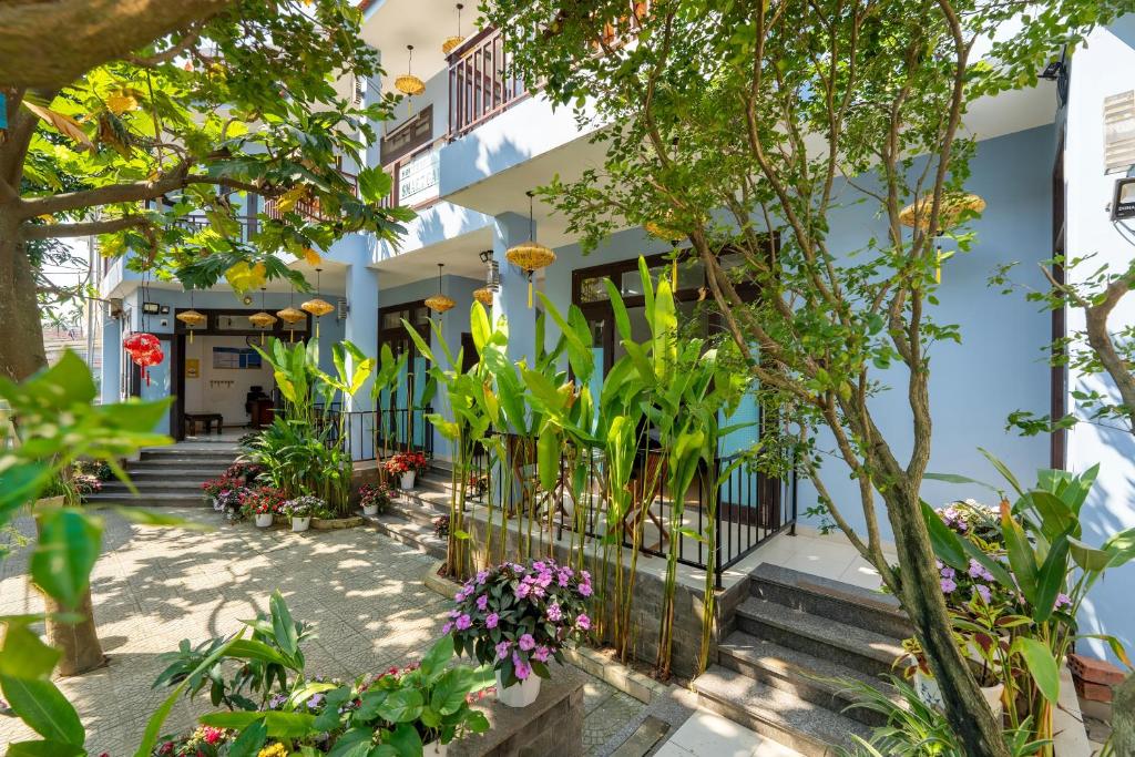 a building with plants and flowers in front of it at Smart Garden Homestay in Hoi An