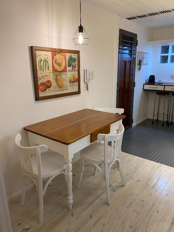 a dining room table with two white chairs around it at Verde Laurel in Concepción del Uruguay