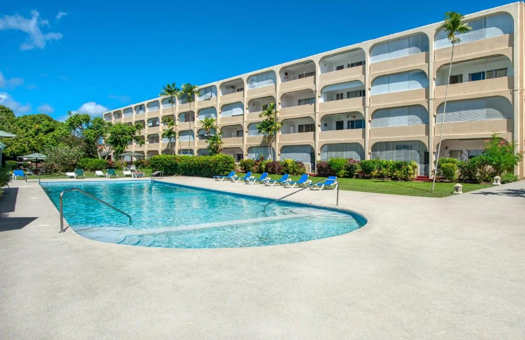a swimming pool in front of a building at Golden Gem Cosy Apartment with pool & garden view in Saint James