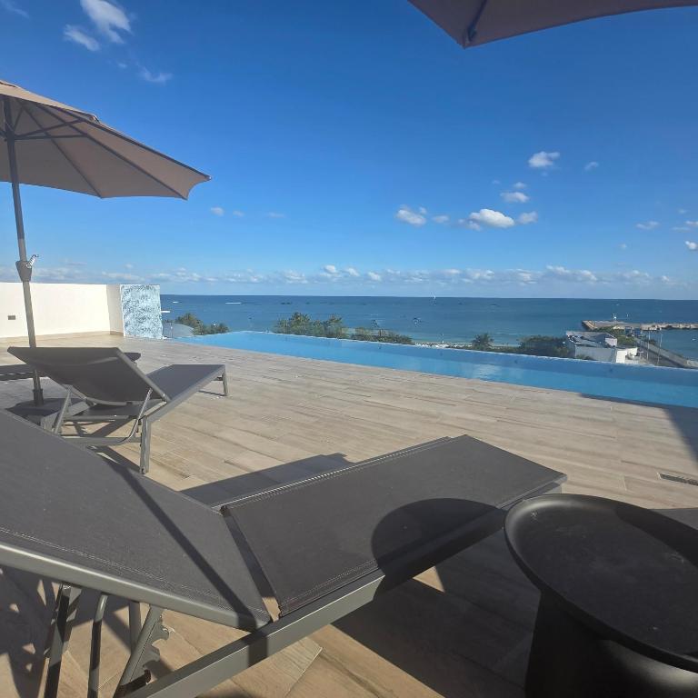 a patio with an umbrella and a table and chairs at MIRAMARE Ocean View in Puerto Morelos