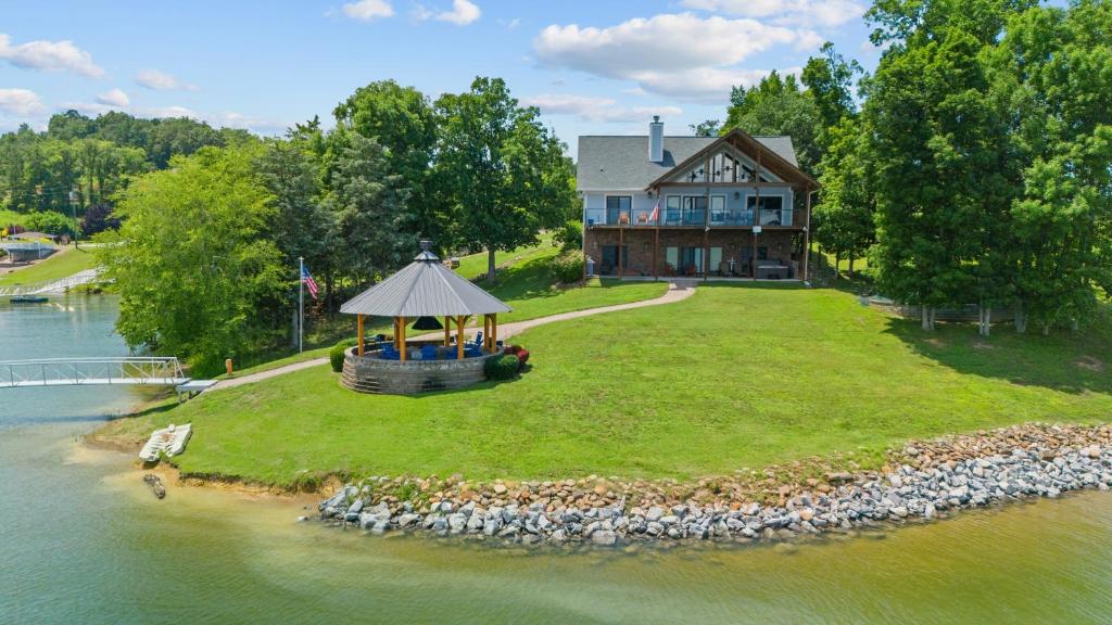 a house on a small island in the water at Cozy Cabin Style Lake House w Theatre Room & Dock in Sevierville