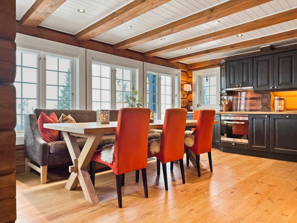a kitchen with a table and chairs and a couch at Mountain Lodge with Jacuzzi & Views in Aurdal