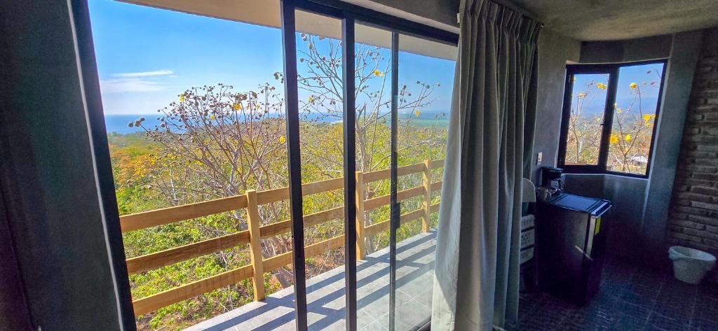 ein Zimmer mit Fenster und Blick auf ein Feld in der Unterkunft Parcela in Mazunte
