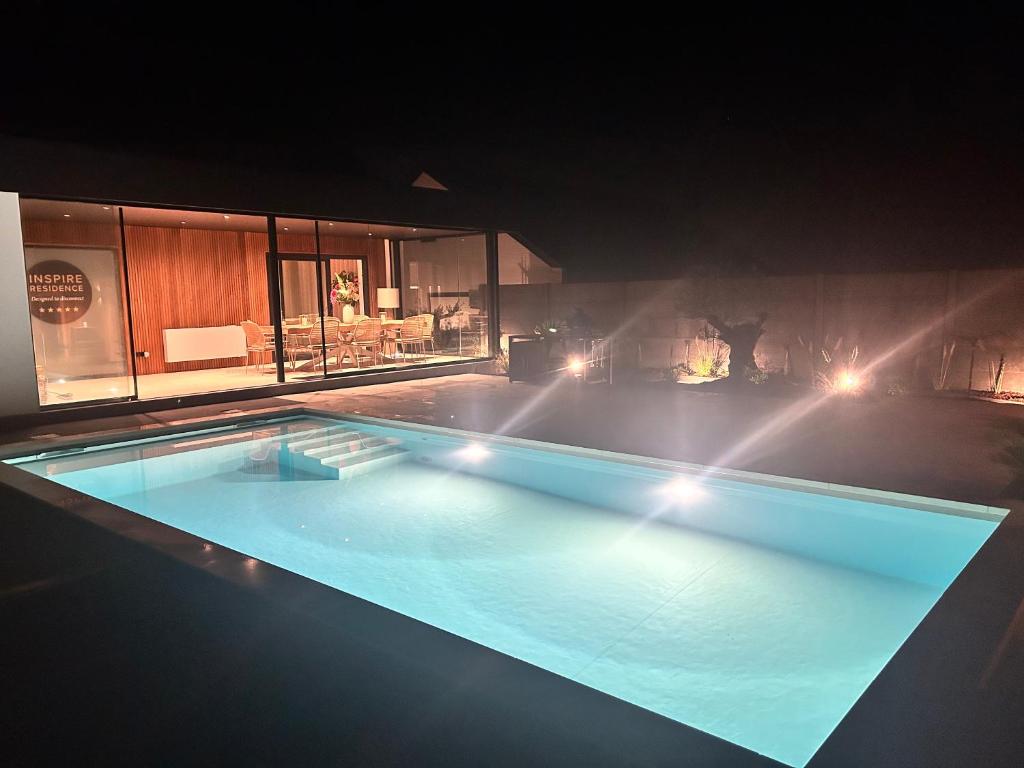 a large swimming pool with lights in a building at Inspire Residence and private Wellness in Tongeren