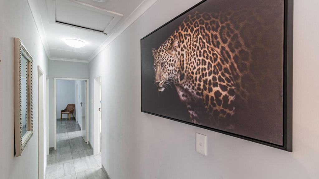 ein Flachbildfernseher, der an einer Wand hängt in der Unterkunft Cottage Protea in Doornrandjies