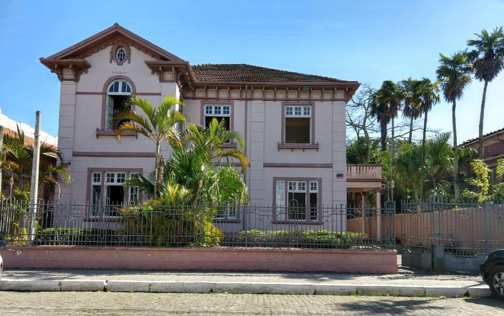 a pink house with a fence in front of it at Vila Santa Eulália Hostel in Pelotas