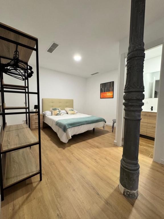 Un dormitorio con una litera y un poste. en Apartamentos Melisa - Madrid, en Madrid