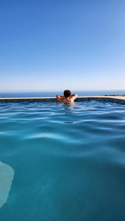 a man in a swimming pool near the ocean at La Cabane Surf Lodge in Agadir