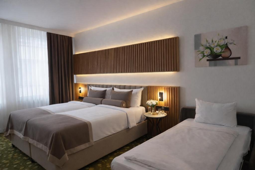 una camera d'albergo con due letti e un tavolo di Hotel Bayer's a Monaco