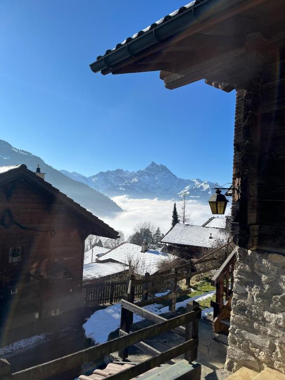 a view of the mountains from a house in the snow at Chalet Les Marmouzets in Gryon
