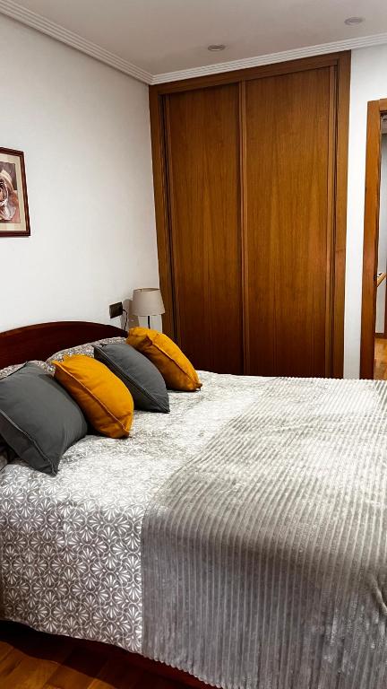 a bedroom with a bed with yellow pillows on it at Acogedor piso céntrico in Lugo