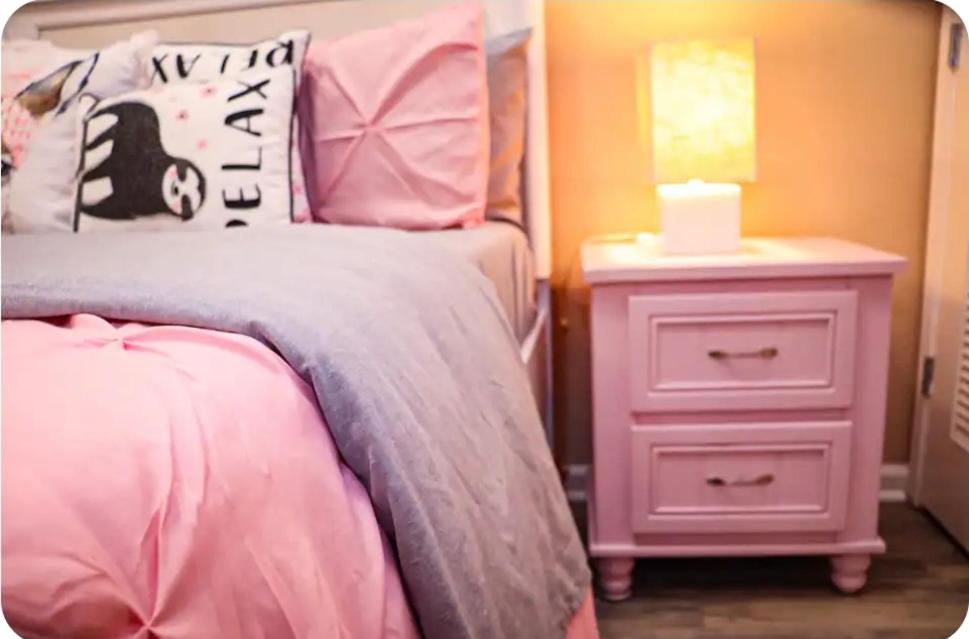 a bedroom with a bed and a night stand with a lamp at The Monthly stay Apartment for 8, pool and grill in Greensboro