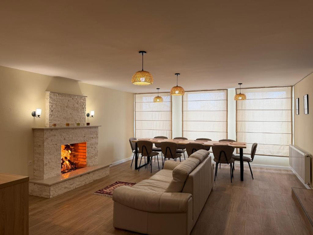 a dining room with a table and a fireplace at Amavilla Hotel in Telavi