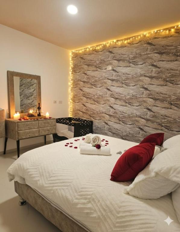 a bedroom with a large bed with a stone wall at צימר נתיב המעיין in Ein Kinya
