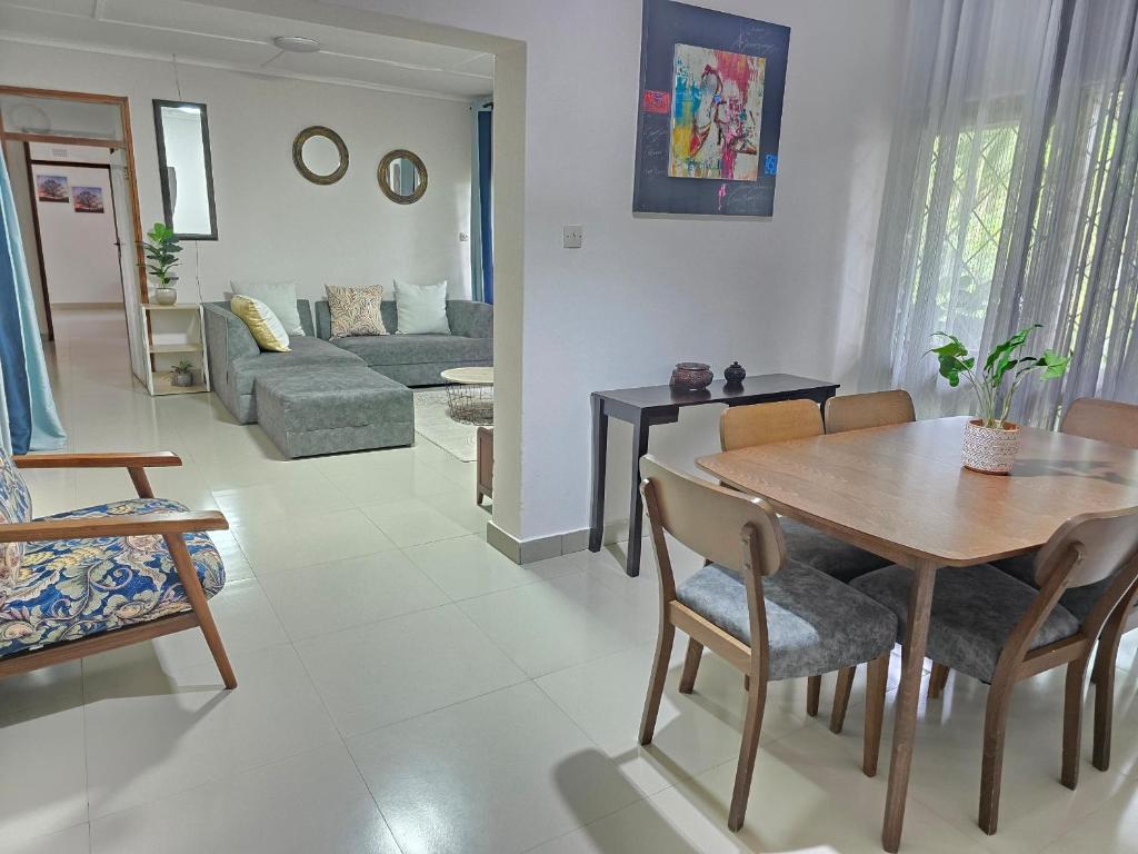 a living room with a wooden table and chairs at Zachi Eland Apartment in Kitwe