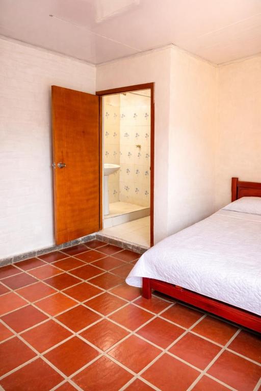 a bedroom with a bed and a tiled floor at Casa sendai2 in Buesaco